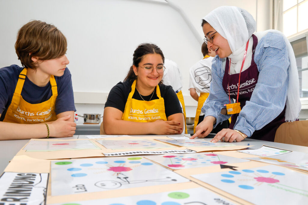 Alles Käse? Studierende erläutern einer Schülerin ein wenig Theorie der Käseherstellung. (Foto: Stefan F. Sämmer)