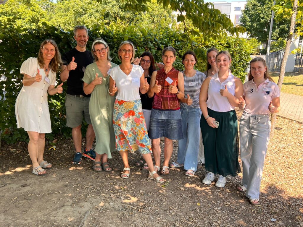 Die drei Studentinnen der JGU – (von rechts) Greta Hafeneger, Mariel-Sophie Sprock und Rahel Schneider – mit dem Team von GO for Tansania e. V. beim Sommerfest des GMO (© GO for Tansania e. V.)