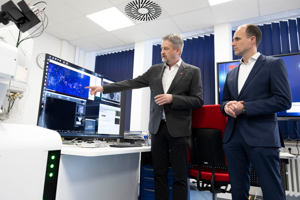 Clemens Hoch, Wissenschaftsminister von Rheinland-Pfalz (r.), und Laborleiter Dr. Stephan Buhre bei der Einweihung des neuen Elektronenstrahl-Mikrosonden-Labors der JGU (Foto: Peter Pulkowski)