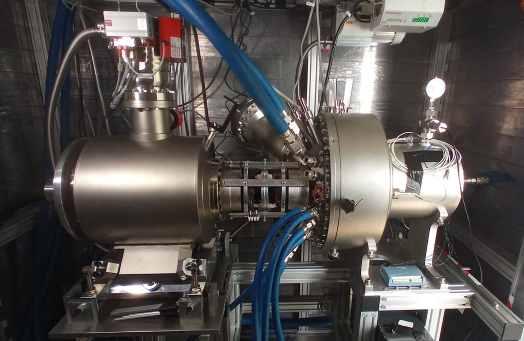 Line Focus X-ray Tube (LFXT-1) mit einer Länge von rund 1,5 Metern im derzeitigen Aufbau an der Technischen Universität München: Der Teil vom linken Rand bis zu den blauen Kühlwasserschläuchen ist die Mainzer Konstruktion. (Foto/©: Thomas Beiser / Helmholtz-Institut Mainz)