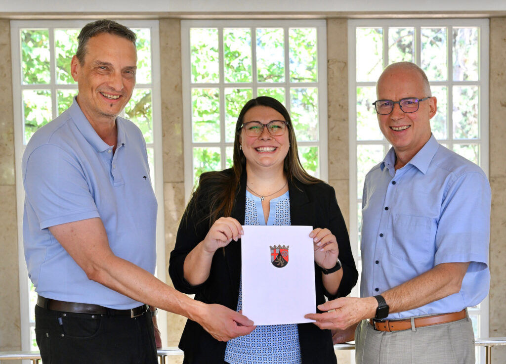 Im Rahmen ihres Antrittsbesuchs an der JGU überreichte Dr. Tamara Müller, Staatssekretärin im Ministerium für Wissenschaft, Weiterbildung und Gesundheit (MWWG) des Landes Rheinland-Pfalz, einen Förderbescheid über 1,5 Millionen Euro in der Förderlinie "Forschungsfonds Rheinland-Pfalz – Förderung regionaler Forschungsexzellenz, Ideen und Strukturen" an JGU-Präsident Prof. Dr. Georg Krausch (r.) und Prof. Dr. Stefan Müller-Stach (l.), Vizepräsident für Forschung und wissenschaftliche Karrierewege. (Foto: Peter Pulkowski)