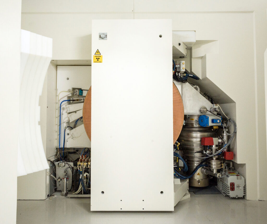 Zyklotron mit geöffnetem Strahlungsschild mit Blick auf die Targets (links), den Magneten und das Zyklotron (Mitte) sowie das Vakuumsystem (rechts) (Foto: Stefan F. Sämmer)